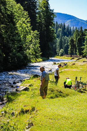 Iezer Mountains - Romania - 2019. People relaxing next to a river, and having barbeque.のeditorial素材