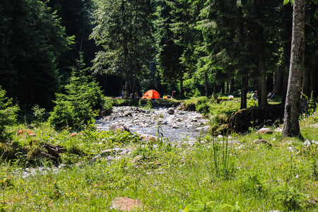 Iezer Mountains - Romania - 2019. People relaxing next to a river, and having barbeque.のeditorial素材