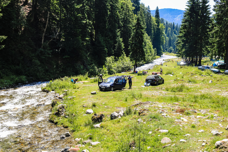 Iezer Mountains - Romania - 2019. People relaxing next to a river, and having barbeque.のeditorial素材