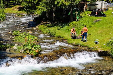 Iezer Mountains - Romania - 2019. People relaxing next to a river, and having barbeque.のeditorial素材