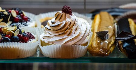Desserts, pastries, cakes and various sweets at cafeteria and coffee shop window. Many different fresh tasty desserts  mousse, souffle, ecler cake.の写真素材