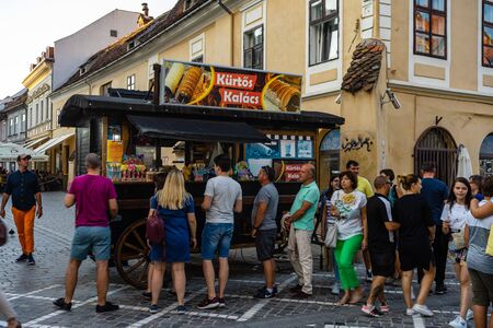 Brasov, Romania - 2019. Tourists waiting in line to buy Kurtos Kolacs.のeditorial素材