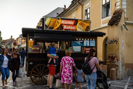 Brasov, Romania - 2019. Tourists waiting in line to buy Kurtos Kolacs.のeditorial素材