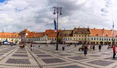 Sibiu, Romania - 2019. Tourist wondering in the panoramic The Big Square (Piata Mare) of Sibiu looking and the City hall.のeditorial素材
