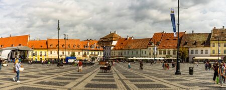 Sibiu, Romania - 2019. Tourist wondering in the panoramic The Big Square (Piata Mare) of Sibiu looking and the City hall.のeditorial素材