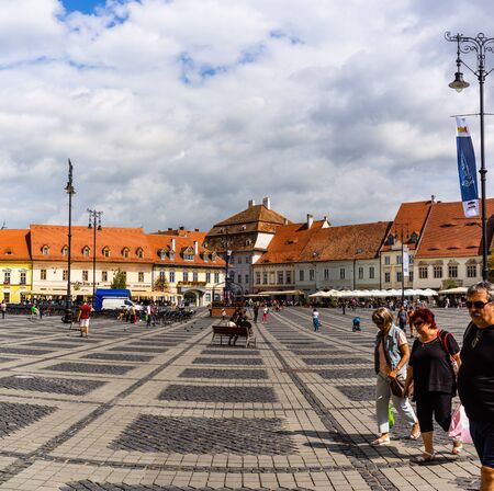 Sibiu, Romania - 2019. Tourist wondering in the panoramic The Big Square (Piata Mare) of Sibiu looking and the City hall.のeditorial素材