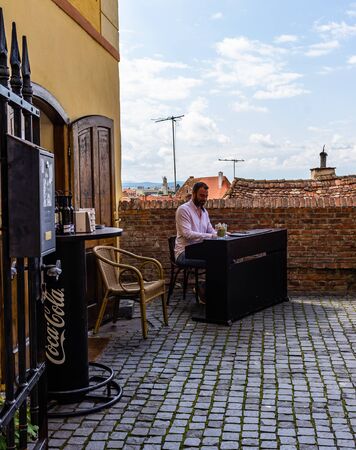 Sibiu, Romania - 2019. Young man playing piano at a local coffee shop in Sibiu.のeditorial素材