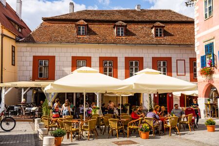 Sibiu, Romania - 2019. People and tourists having lunch and wandering on the streets of Sibiu old town.のeditorial素材