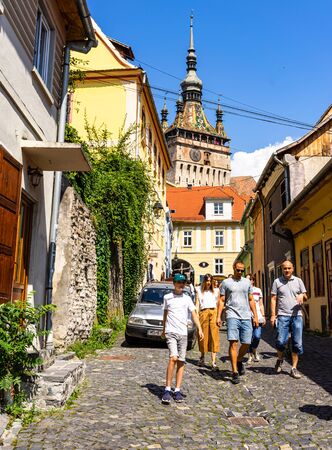 Sighisoara, Romania - 2019. People wandering on the streets of Sighisoara citadel (old town). Streets with colorful houses.のeditorial素材