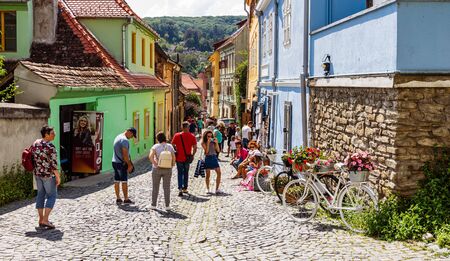 Sighisoara, Romania - 2019. People wandering on the streets of Sighisoara citadel (old town). Streets with colorful houses.のeditorial素材