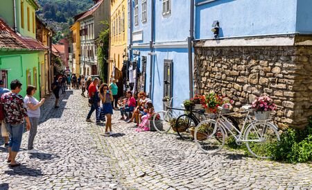 Sighisoara, Romania - 2019. People wandering on the streets of Sighisoara citadel (old town). Streets with colorful houses.のeditorial素材