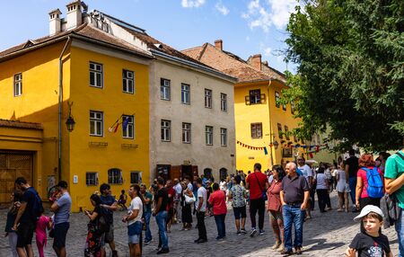 Sighisoara, Romania - 2019. People wandering on the streets of Sighisoara citadel (old town). Streets with colorful houses.のeditorial素材