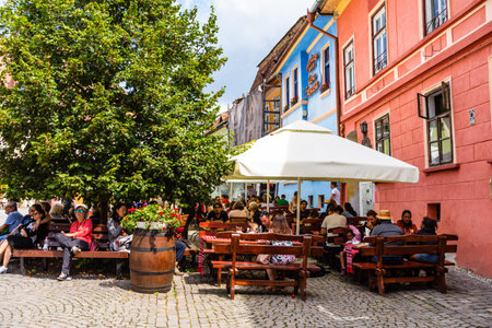 Sighisoara, Romania - 2019. People having lunch and wandering on the streets of Sighisoara old town.
