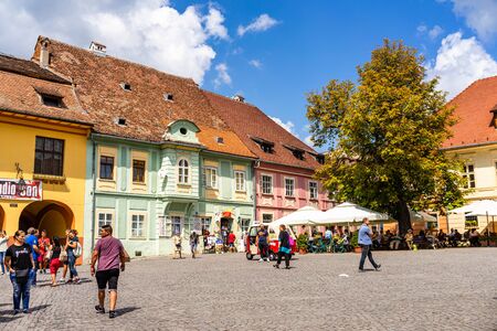 Sighisoara, Romania - 2019. People wandering on the streets of Sighisoara citadel (old town). Streets with colorful houses.のeditorial素材