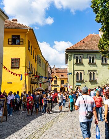 Sighisoara, Romania - 2019. People wandering on the streets of Sighisoara citadel (old town). Streets with colorful houses.のeditorial素材