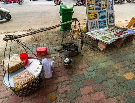 Ho Chi Minh City, Vietnam â 2019. Woman selling food on the street. Delicious snacks food for locals.のeditorial素材
