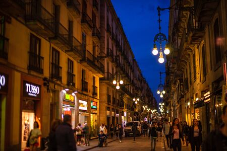 Barcelona, Spain â 2019. People walking on the old streets of Barcelona at night between local shops and tapas bars.のeditorial素材