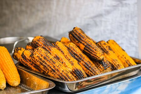 Grilled, roasted sweet corn ready to sell at a street food festivalの写真素材