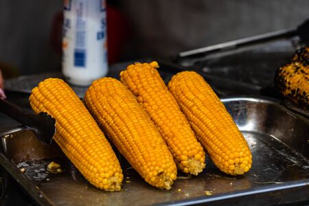Grilled, roasted sweet corn ready to sell at a street food festivalの写真素材