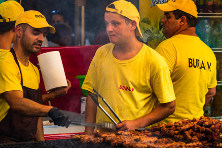 Chef preparing meat on the grill, pork steaks, chicken breast, sausages, pieces of meat chops at a food festival in Bucharest, Romania â 2019のeditorial素材