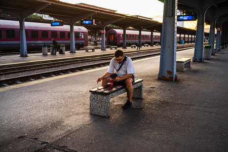 Travelers waiting for a train, sitting on a bench on the platform of Bucharest North Railway Station (Gara de Nord) in Bucharest, Romania, 2019のeditorial素材