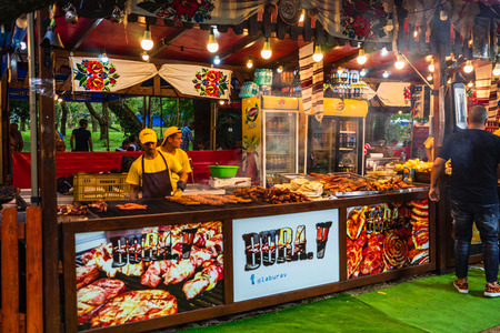 Chef preparing meat on the grill, pork steaks, chicken breast, sausages, pieces of meat chops at a food festival in Bucharest, Romania â 2019のeditorial素材