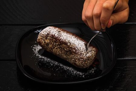 Eating cocoa cake with sugar powder. Close up photo.の写真素材