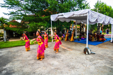 Balinese women dancers in a traditional Bali dress costume performing a show. Girls performing...