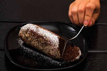 Eating cocoa cake with sugar powder. Close up photo.の写真素材