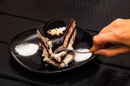 Eating creamy cheesecake with chocolate cookies and cream biscuits.の写真素材