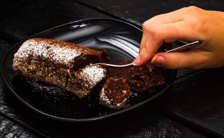 Eating cocoa cake with sugar powder. Close up photo.の写真素材
