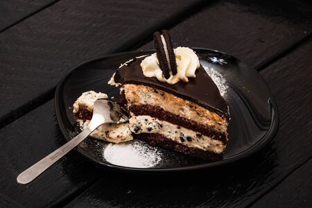 Eating creamy cheesecake with chocolate cookies and cream biscuits.の写真素材