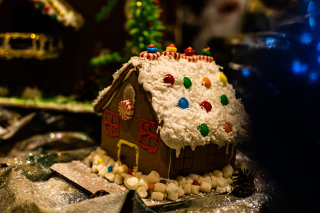 Christmas decorations against blurred background. Ginger house with candies.