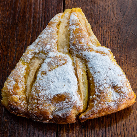 Freshly baked apple pie with sugar powder on a wooden board. Homemade apple cake.