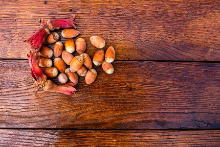 Red hazelnuts on a wooden board. Isolated hazelnuts.の写真素材