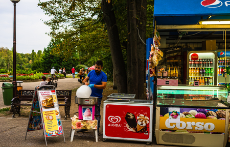 Young man making and selling cotton candy on an alley in the park in Bucharest, Romania, 2019のeditorial素材