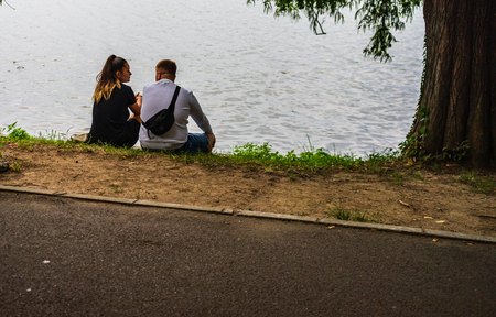 Back view of two youngers standing near a lake in Bucharest, Romania, 2019.のeditorial素材