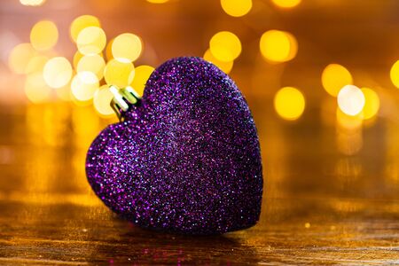 Christmas decorations against blurred background. Glittery heart shaped Christmas ball.の写真素材