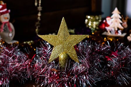 Christmas decorations on wooden board. Glittery Christmas star, colorful garland. Star Christmas tree top.の写真素材