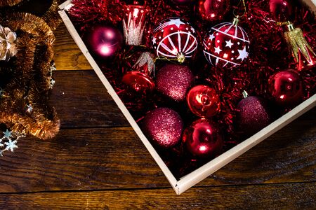 Christmas decorations in a box. Christmas concept. Box with red Christmas balls and garlands.の写真素材
