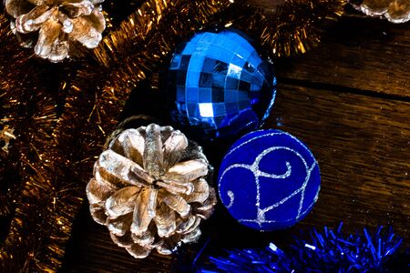 Christmas decorations on wooden board. Christmas concept. Pine cone and blue Christmas balls.の写真素材