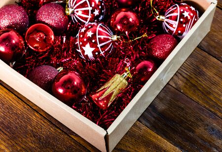 Christmas decorations in a box. Christmas concept. Box with red Christmas balls and garlands.の写真素材