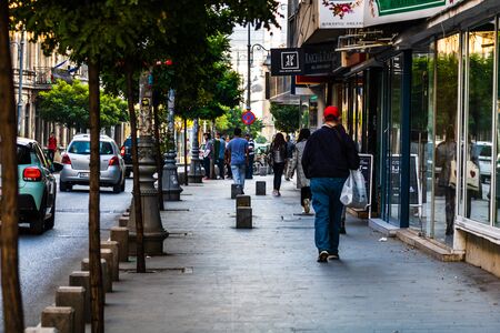 Young man walking on the sidewalk of Victoriei Street in Bucharest, Romania, 2019のeditorial素材