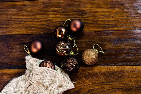Christmas burlap sack with glittery and shiny Christmas decorations. Christmas decorations on wooden board.の写真素材