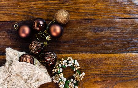 Christmas burlap sack with glittery and shiny Christmas decorations. Christmas decorations on wooden board.の写真素材