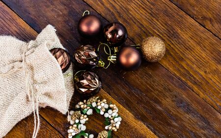 Christmas burlap sack with glittery and shiny Christmas decorations. Christmas decorations on wooden board.の写真素材