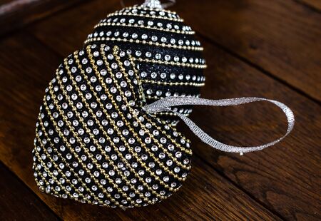 Christmas decorations on wooden board. Christmas concept. Black and shiny Christmas balls. Heart shaped Christmas ball.の写真素材