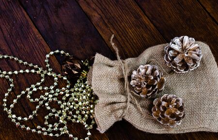 Christmas burlap sack with glittery and shiny Christmas decorations. Christmas decorations on wooden board.の写真素材