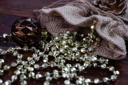 Christmas burlap sack with glittery and shiny Christmas decorations. Christmas decorations on wooden board.の写真素材