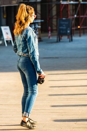 Young girl holding a camera on the streets of Bucharest, Romania, 2019のeditorial素材